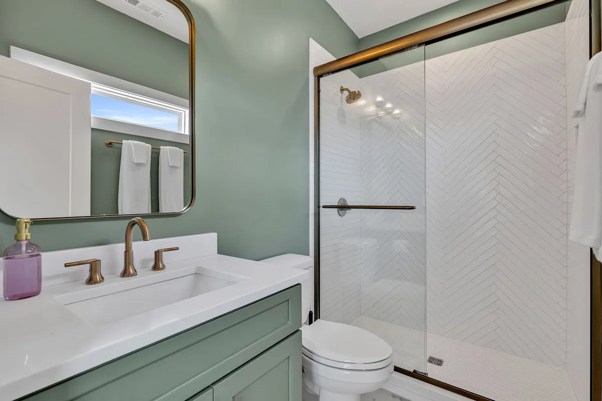 A modern bathroom with a vanity and sink, glass shower, mirror, fresh towels, and elegant lighting fixtures. The mood is calming and rejuvenating, ideal for self-care and morning routines.